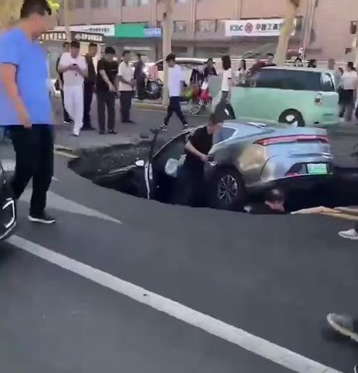 邯郸柏油马路突现深坑，有车辆猝不及防陷落，车主踩着车身从坑内爬出