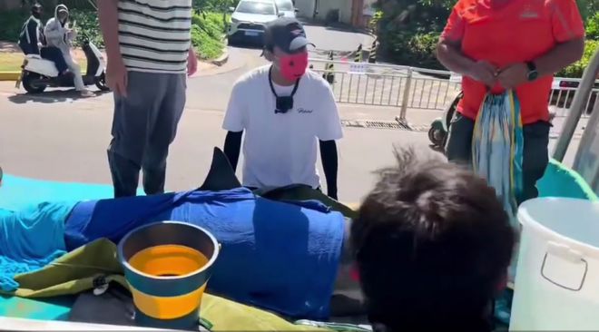 海南万宁2米长海豚搁浅海滩，众人为其披浴巾紧急救助